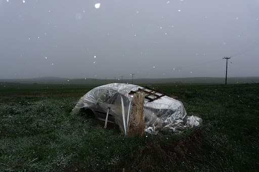 A handmade shelter standing alone in an open field